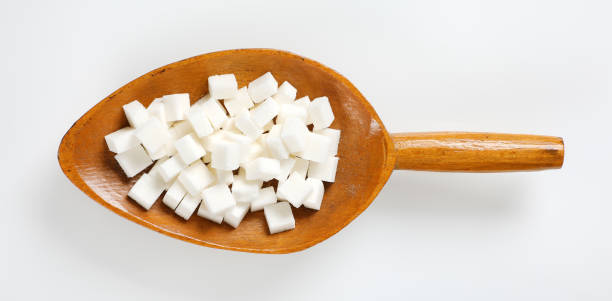 scoop of white sugar cubes on white background