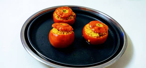 Homemade delicious red tomatoes stuffed with spicy fried rice.