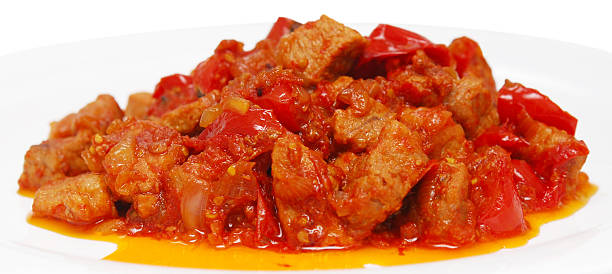 fried meat with tomatoes on a dish closeup